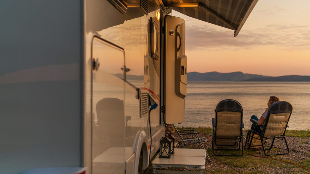 A camper by the beach with an electric rv awning