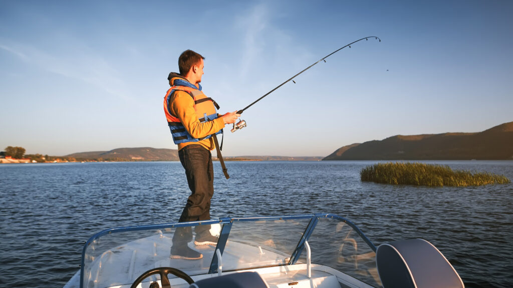 A man out fishing using his travel fishing rod