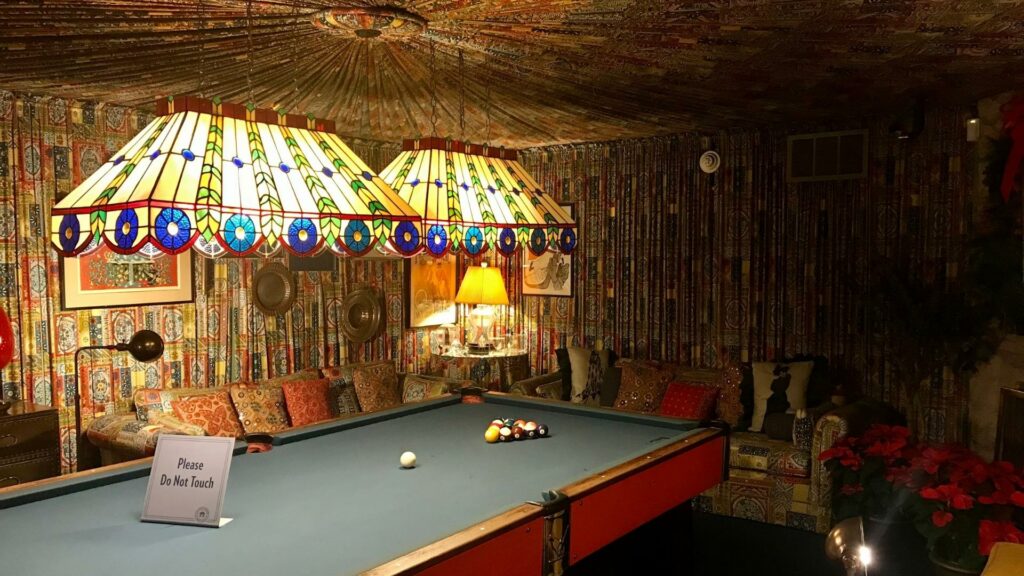 The billiard room in Graceland with fabric walls and stained glass lights