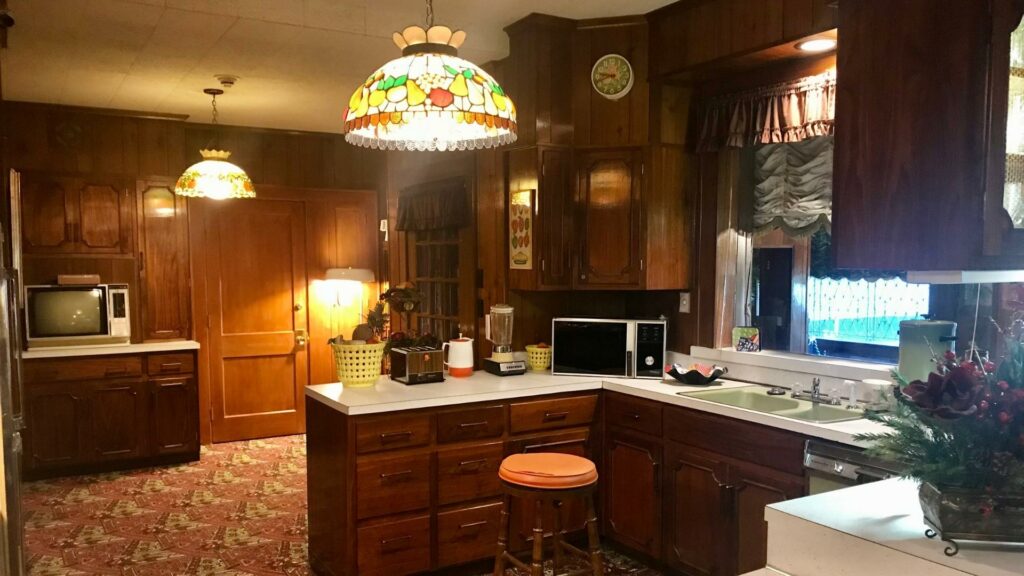 The kitchen in Elvis Presley's house with dark wood cabinets and stained glass lights 