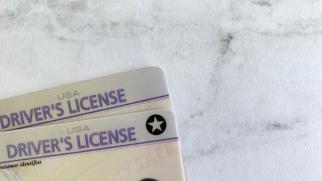 Close up of two drivers licenses, required documentation for getting a title for a trailer without a title