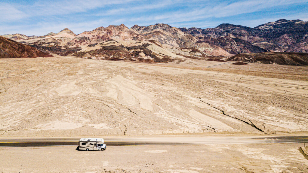 An RV driving down Death Valley national park, in October, one of the best times to visit
