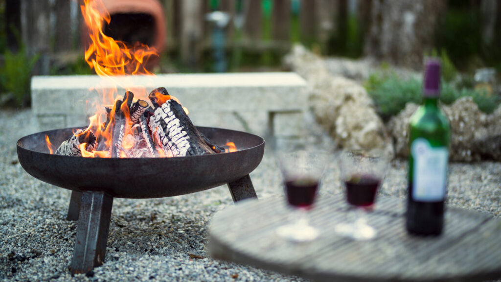 Two wine glasses by a fireplace after being brought over with a wine tot bag, a camping gift for women