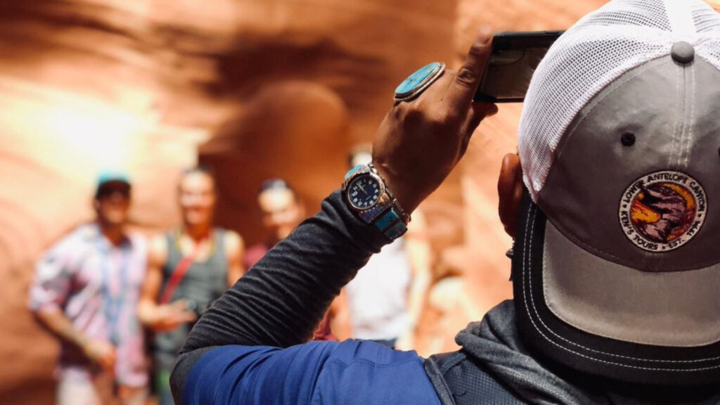 A man taking a photo of his friends inside the lower antelope canyon