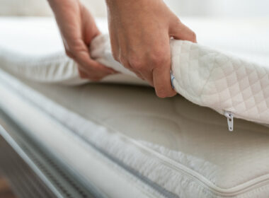 A person putting on their rv mattress topper