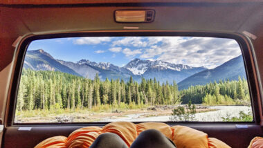 View of a person laying in their vehicle during their fall camping site