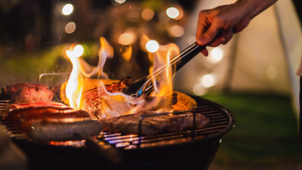 A person using their grill at a campsite 