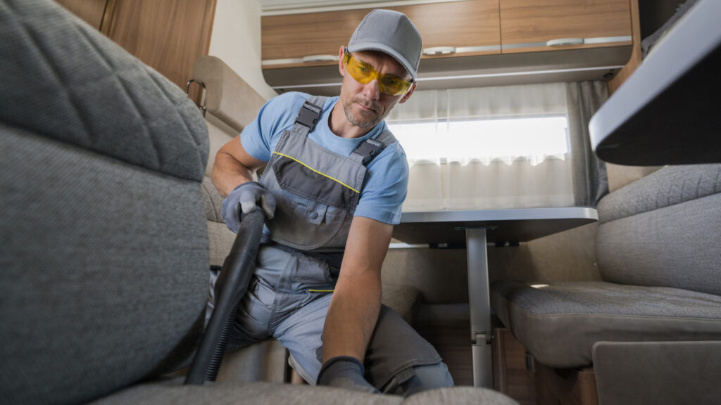 A man using his rv vacuum on his seats