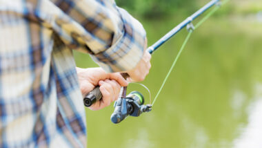 A person fishing using their travel fishing rod