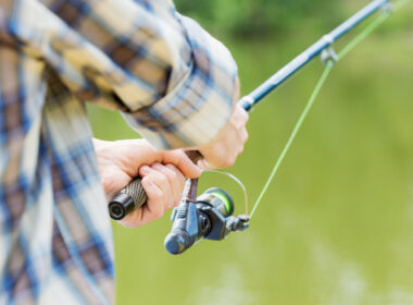 A person fishing using their travel fishing rod