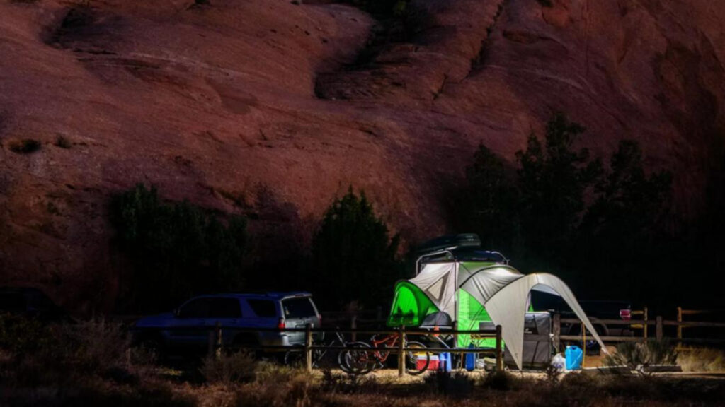 A SylvanSport trailer and tent set up outside at night