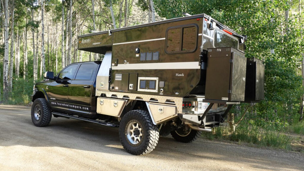 A flatbed 4 wheel camper attached to a truck 