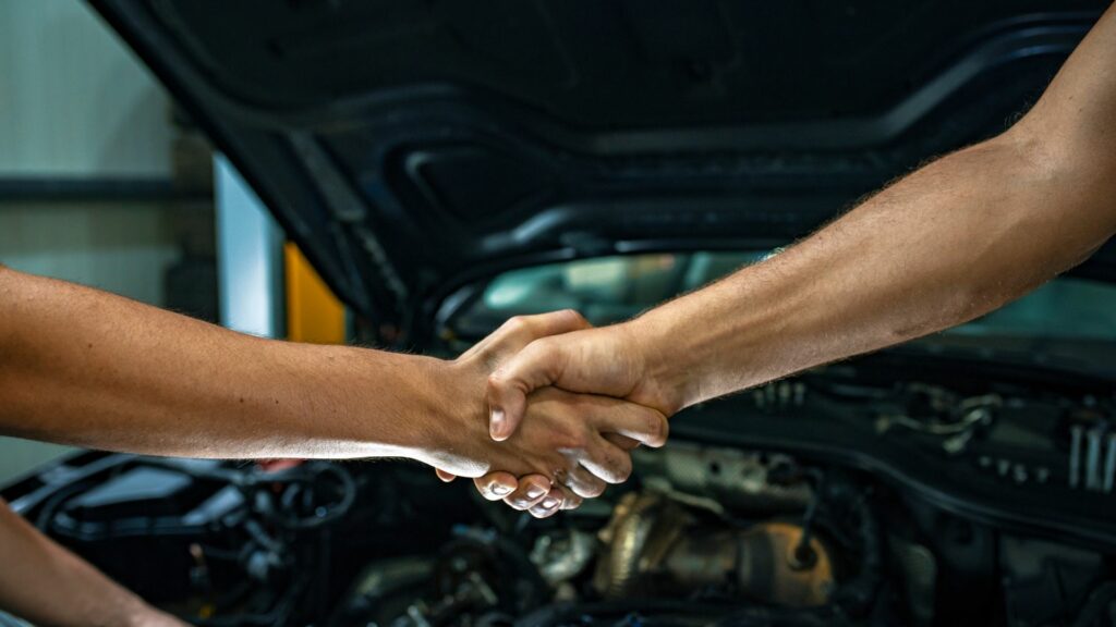 A person shaking hands with a mechanic after having their front differential fixed