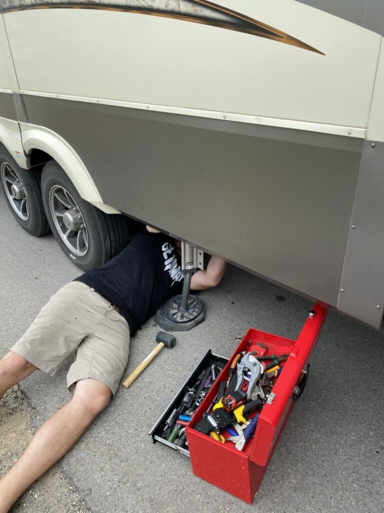 Jason under our RV trying to fix a broken jack 