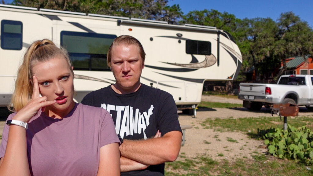 Us stressed out from decision fatigue standing in front of our RV in a campground while RVing America