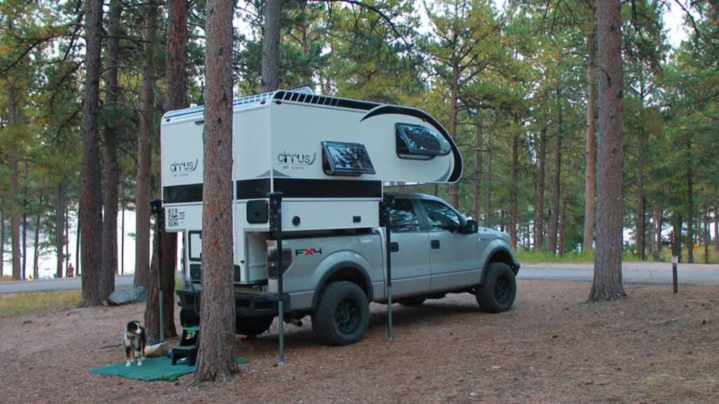 A truck using one of the best truck camper jacks out in the woods