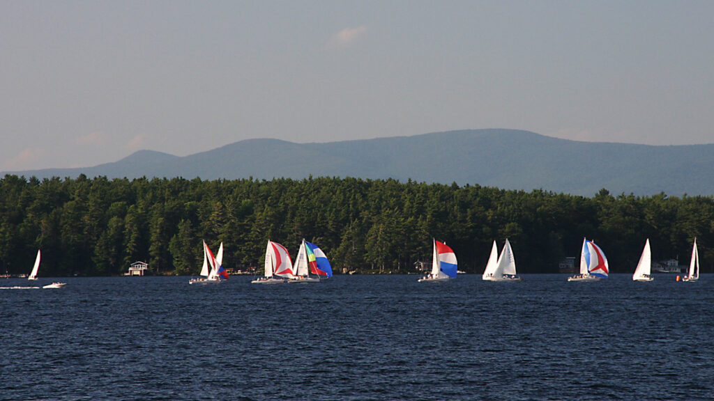 View of sailboats in lake winnipesaukee by multiple campgrounds