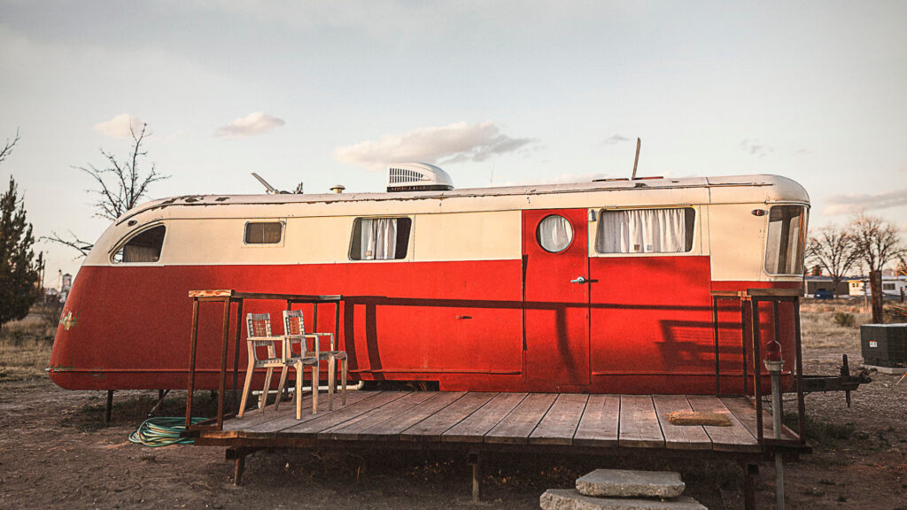 A red RV with a porch