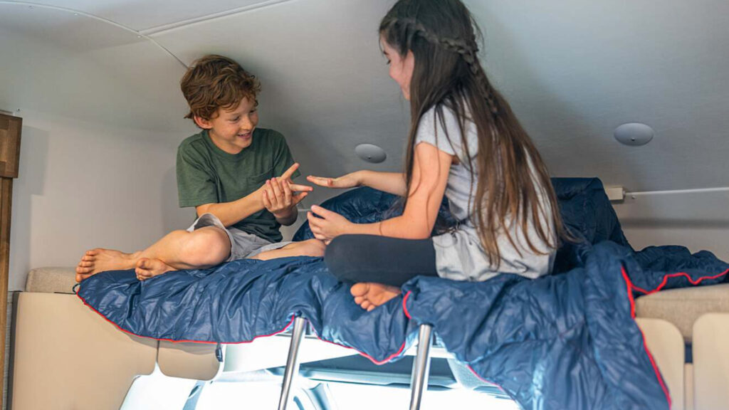 Two kids playing in their RV with a loft
