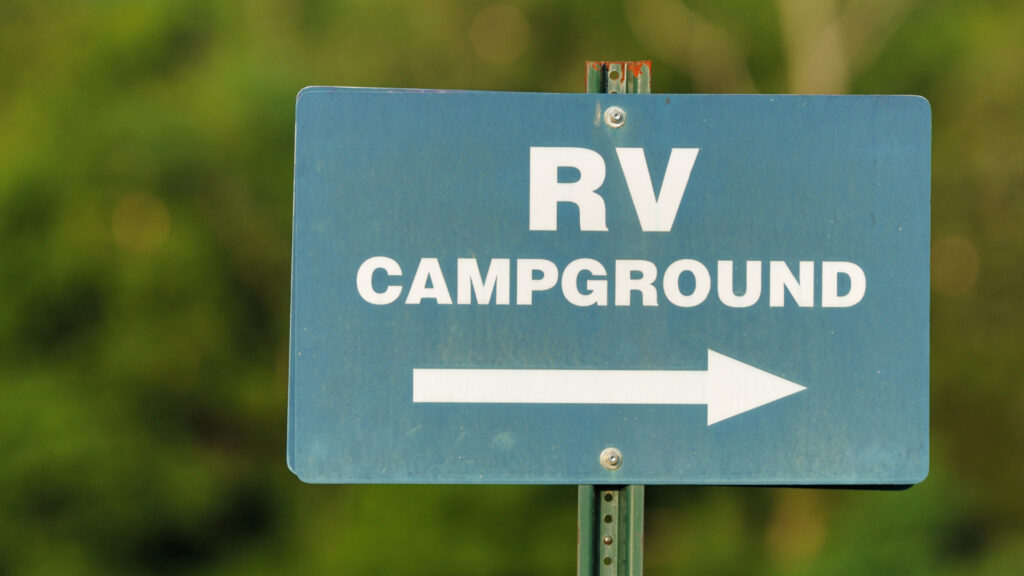 A sign pointing to an RV campground for RVers arriving late at night