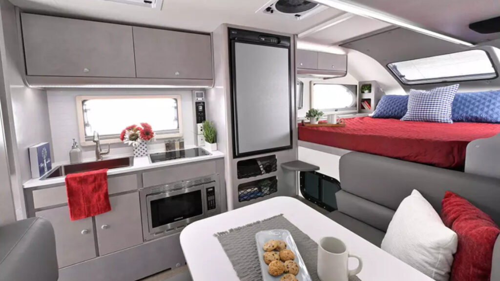 The sleeping and kitchen area inside a nuCamp Cirrus 820 short bed truck camper