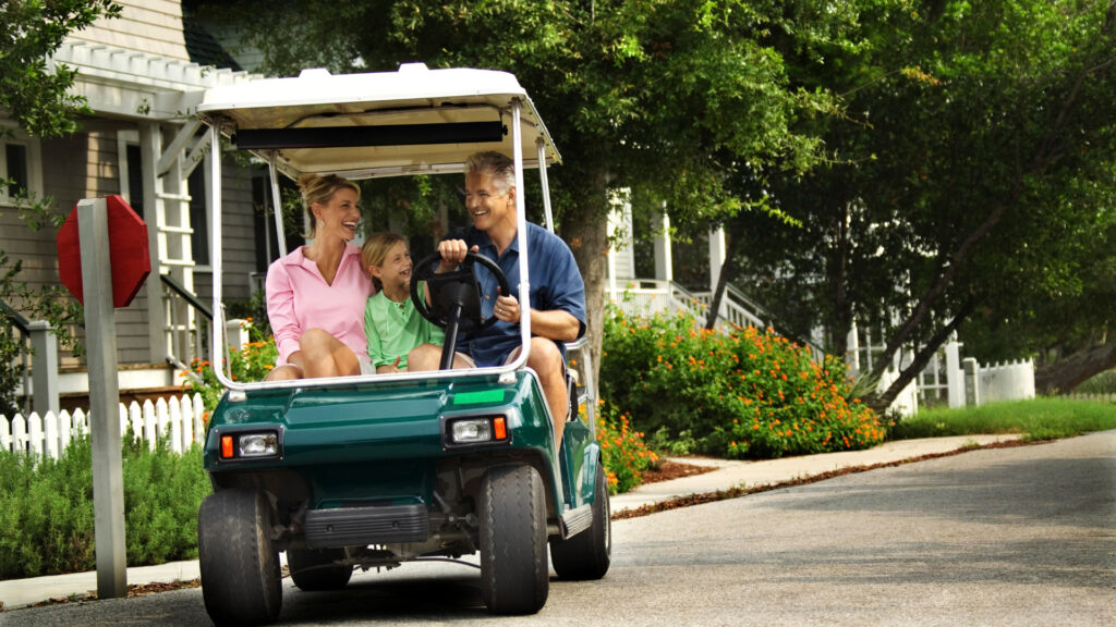 A family driving down the road in their street legal golf cart