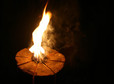 A lit swedish fire log at night