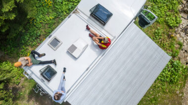 A group of friends sitting on their RV next to their ducted RV air conditioner
