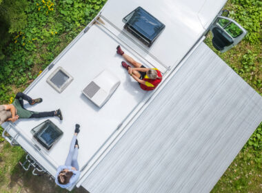 A group of friends sitting on their RV next to their ducted RV air conditioner