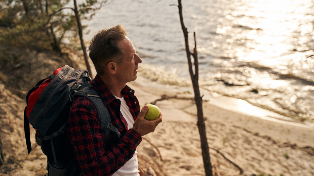 A man eating an apple, a popular hiking snack