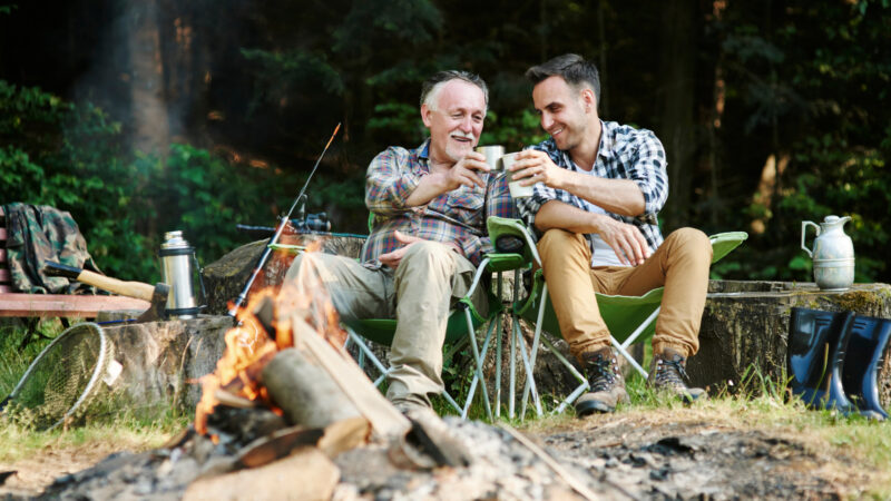 A father and son drinking from mugs from an rv gift guide for dad