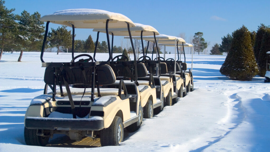 Multiple golf carts in the snow with golf cart heaters