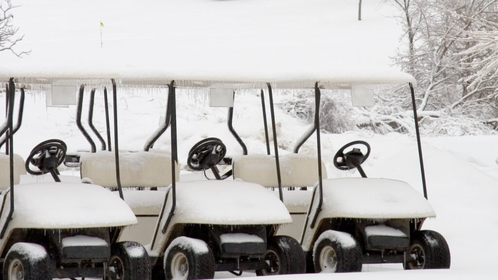 Multiple golf carts in the snow with golf cart heaters