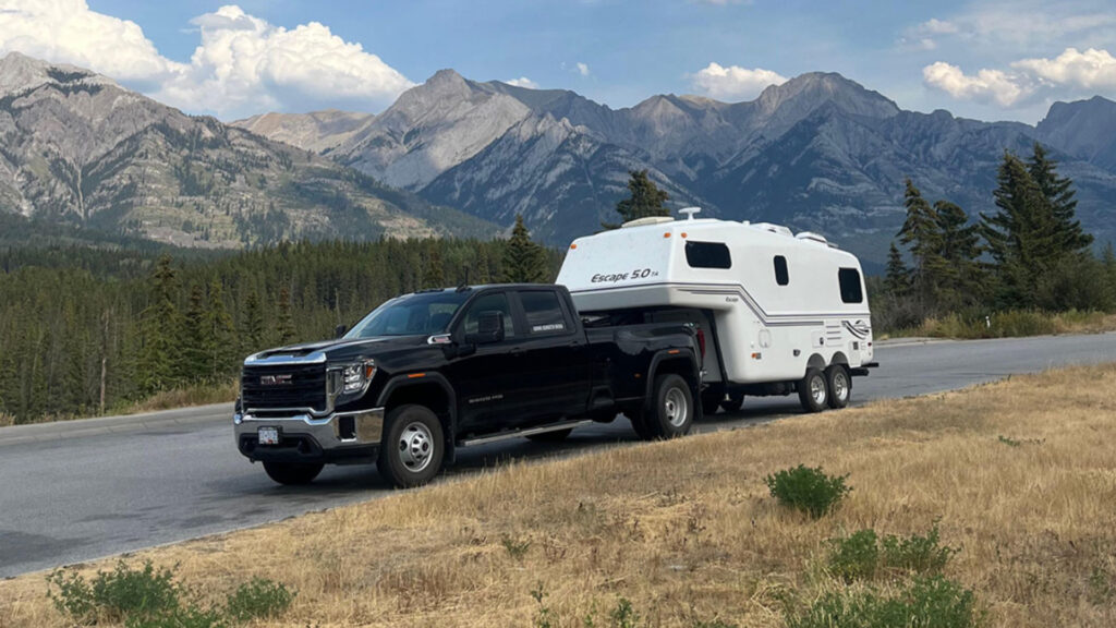 An Escape 5.0 fifth-wheel trailer attached to a truck in the mountains
