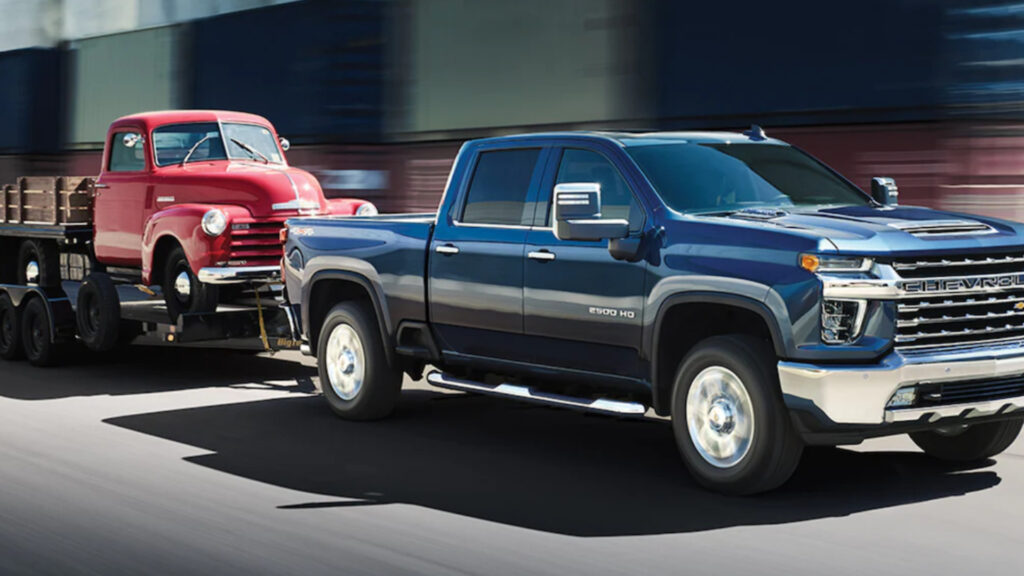 A chevrolet silverado 2500hd using its towing capacity to tow a vehicle