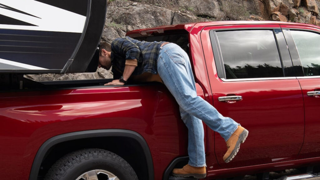 A man looking in the back of his chevrolet silverado 2500hd before towing an RV 