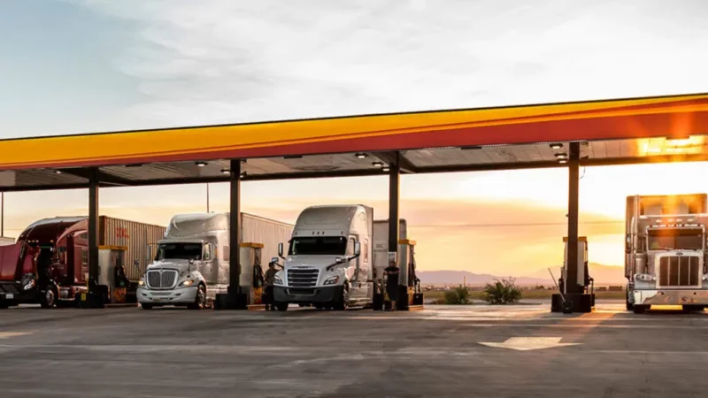 Semis getting gas at a Love's gas station, which now offers full RV hookups