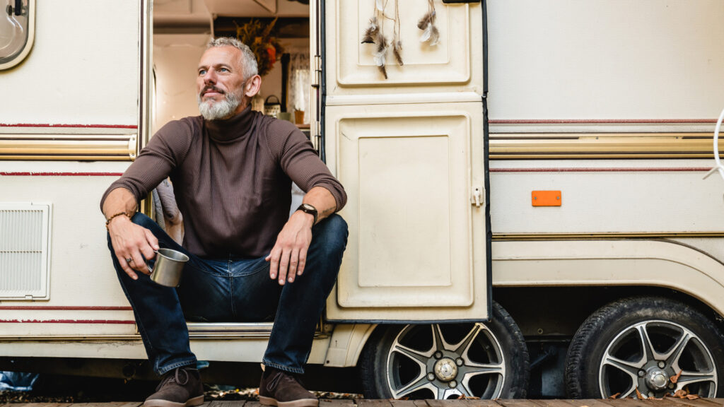 A man sitting outside his RV living the retirement dream