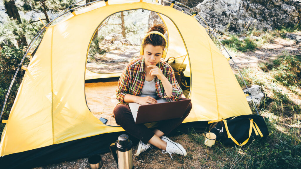A woman in her camping tent trying to reserve a campground reservation using wandering labs