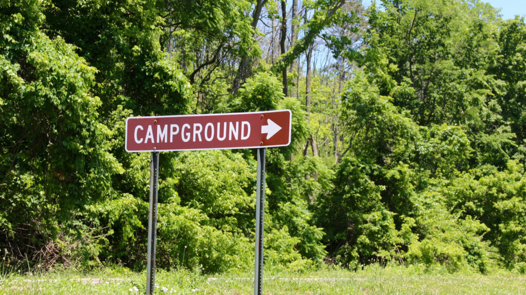 A sign to an RV campground reserved using wandering labs