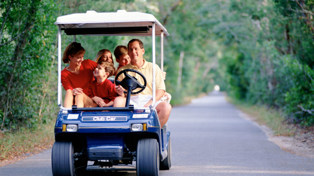 A family in a 6 seat golf cart