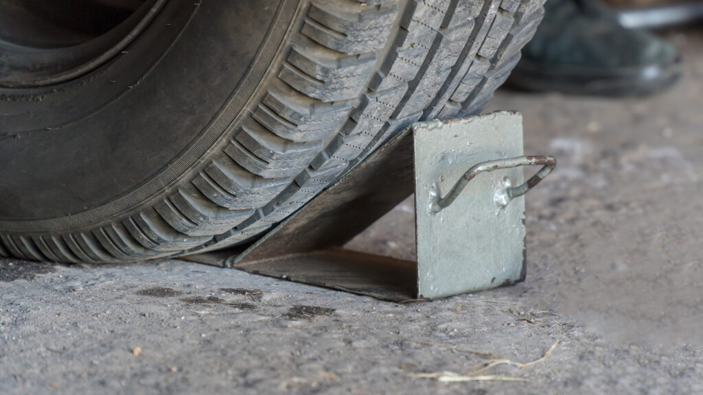 Wheel chocks against a tire during a trailer bearing grease