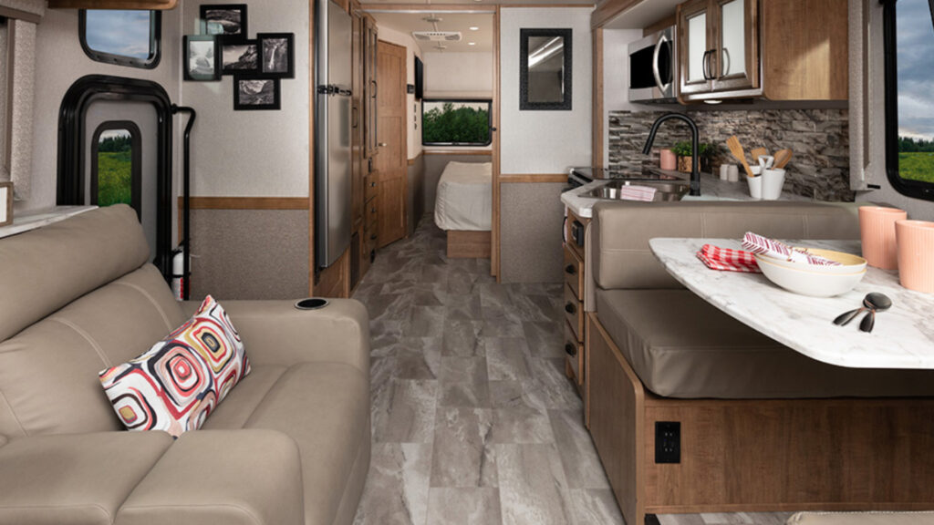 The living and kitchen area of a Holiday Rambler Admiral 33B6 RV that can sleep up to 10 people