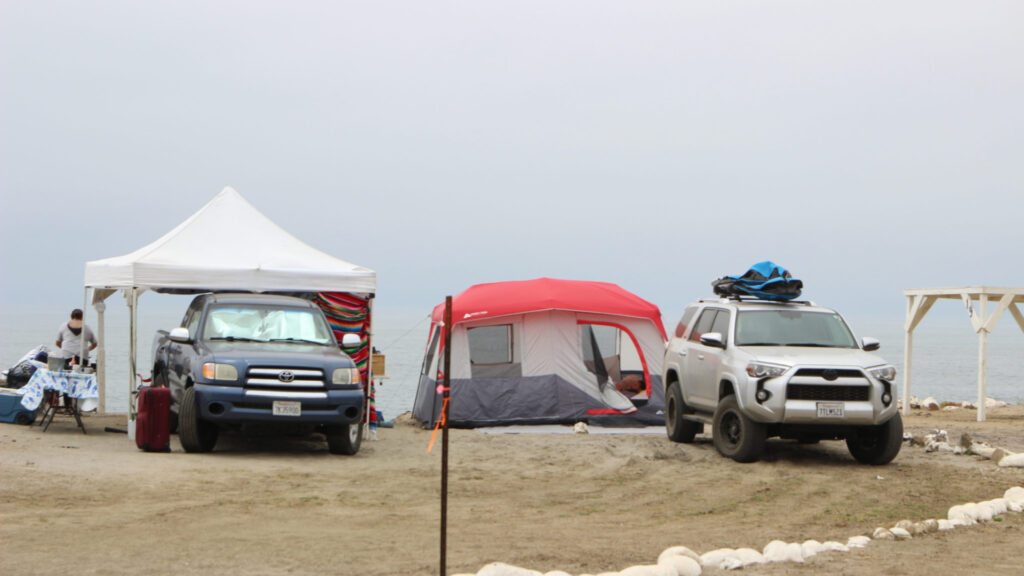 Two trucks camping, parked at Playa Saldamando in Baja