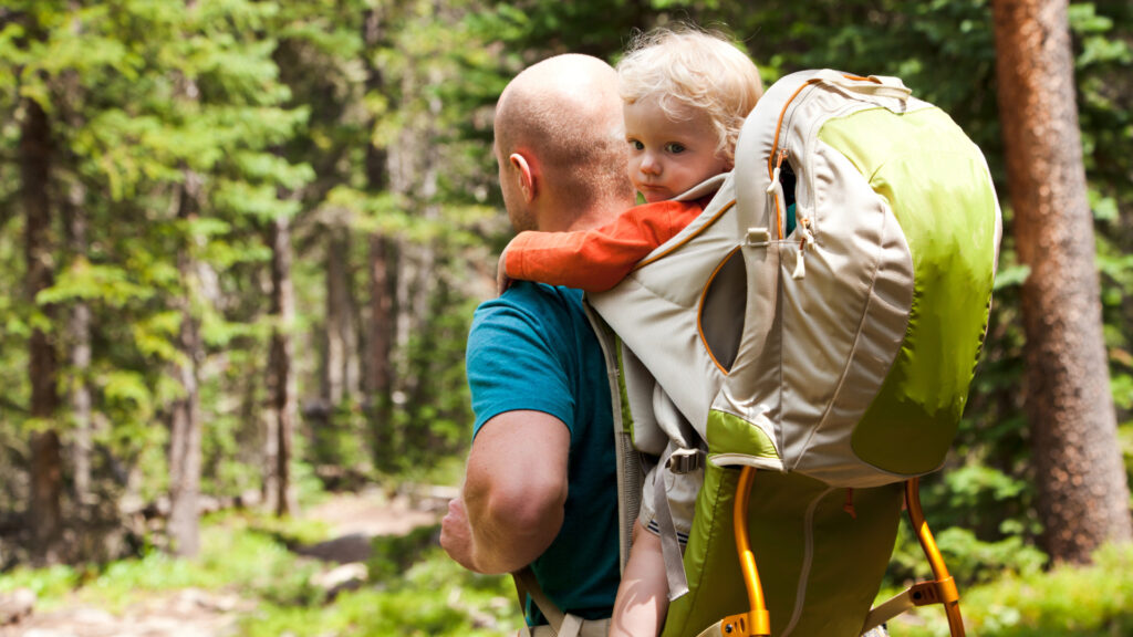 A dad hiking with his child on his back