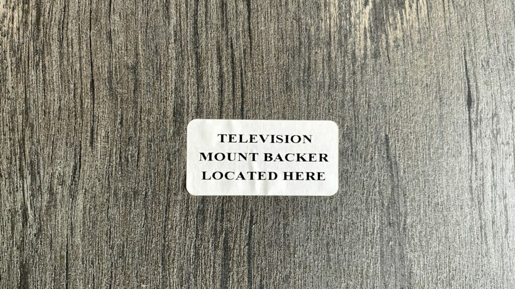 A sticker on an RV wall that says "television mount backer located here".