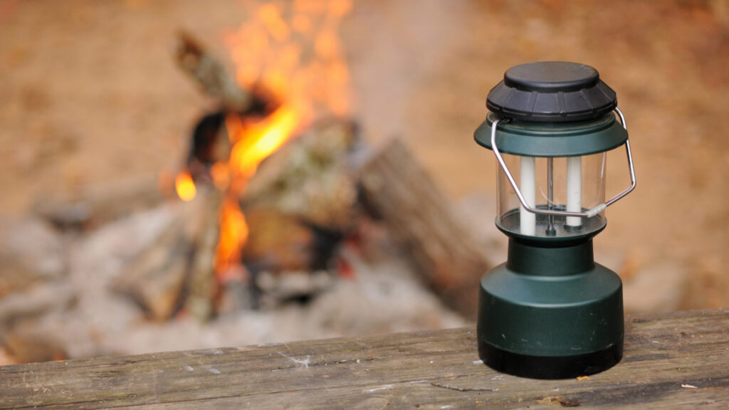 A rechargeable lantern by a campfire