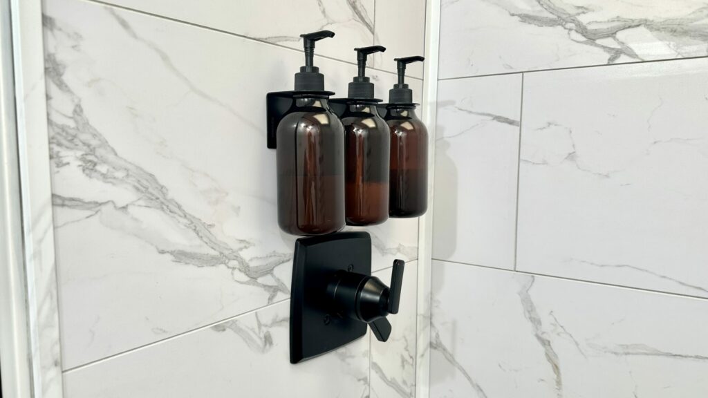 Three soap dispensers installed on the shower wall in our truck camper