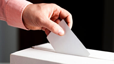 A person submitting their voting ballot in South Dakota