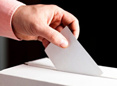 A person submitting their voting ballot in South Dakota